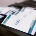 Stack of conference program booklets arranged on a table.